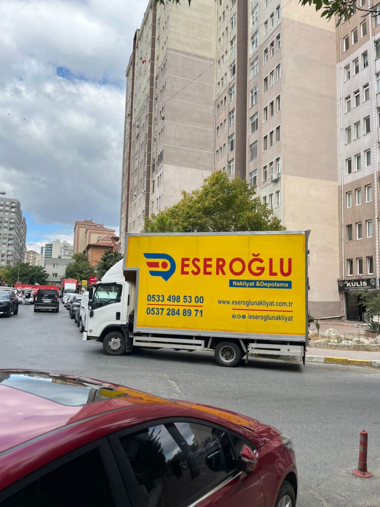 İstanbul sokaklarında park halinde bulunan Eseroğlu Nakliyat & Depolama logolu sarı nakliye kamyonu
